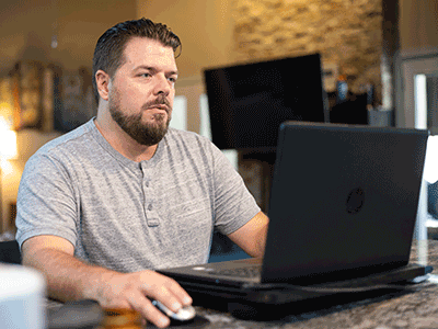 Johnathan sitting at table on laptop.png